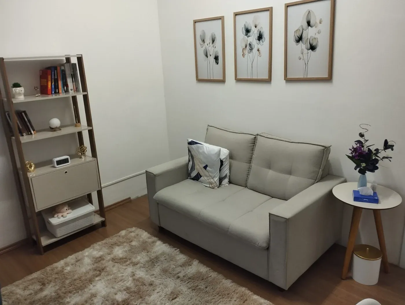 Consultório da Insight Mind com sofá cinza, poltronas azuis e luz natural